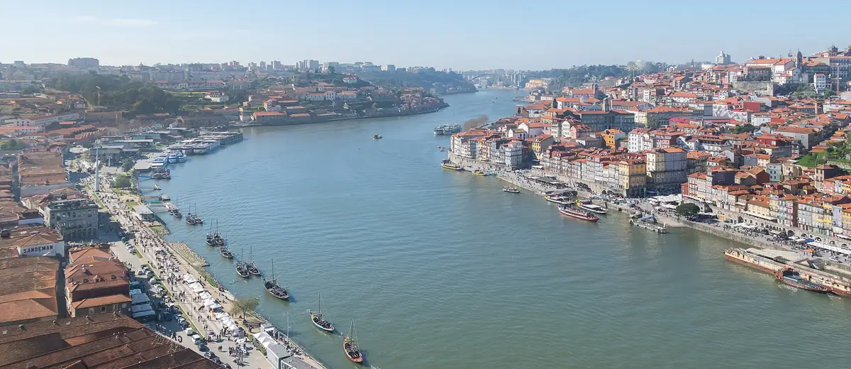 The Douro river winding through Porto, with riverside houses and small boats